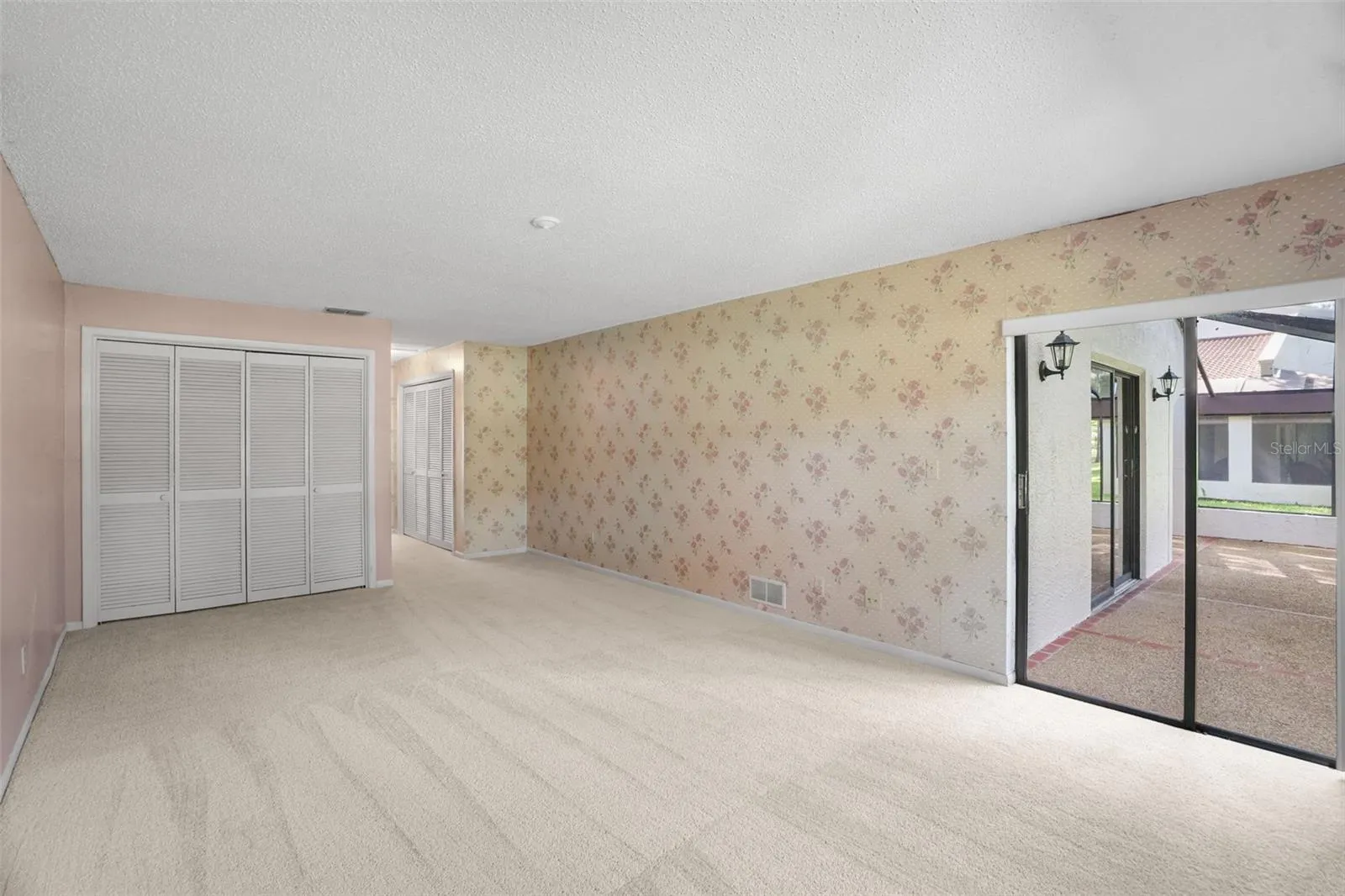 TThe primary bedroom stretches well beyond the usual, with room to create both sleeping and sitting areas. A generous closet provides storage, while a wide sliding glass door opens directly to the screened lanai and brings in plenty of natural light.