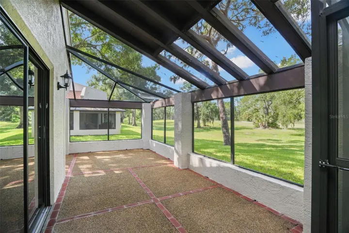 The expansive screened lanai feels almost like another room, with a combination of covered and screened roof sections, textured flooring with brick accents, and broad openings that keep the space bright and airy. There’s plenty of room here for outdoor dining, lounge seating, plants, or all three.