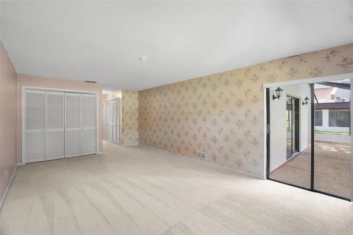 TThe primary bedroom stretches well beyond the usual, with room to create both sleeping and sitting areas. A generous closet provides storage, while a wide sliding glass door opens directly to the screened lanai and brings in plenty of natural light.