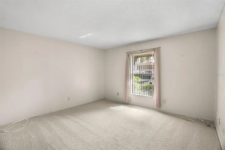 The second bedroom is generously sized at approximately 13' x 14', with newer carpet, a large window for natural light, and enough space for a queen bed, dresser, and desk or reading chair. Its proportions also make it an easy fit for a guest room, home office, or combination of both.