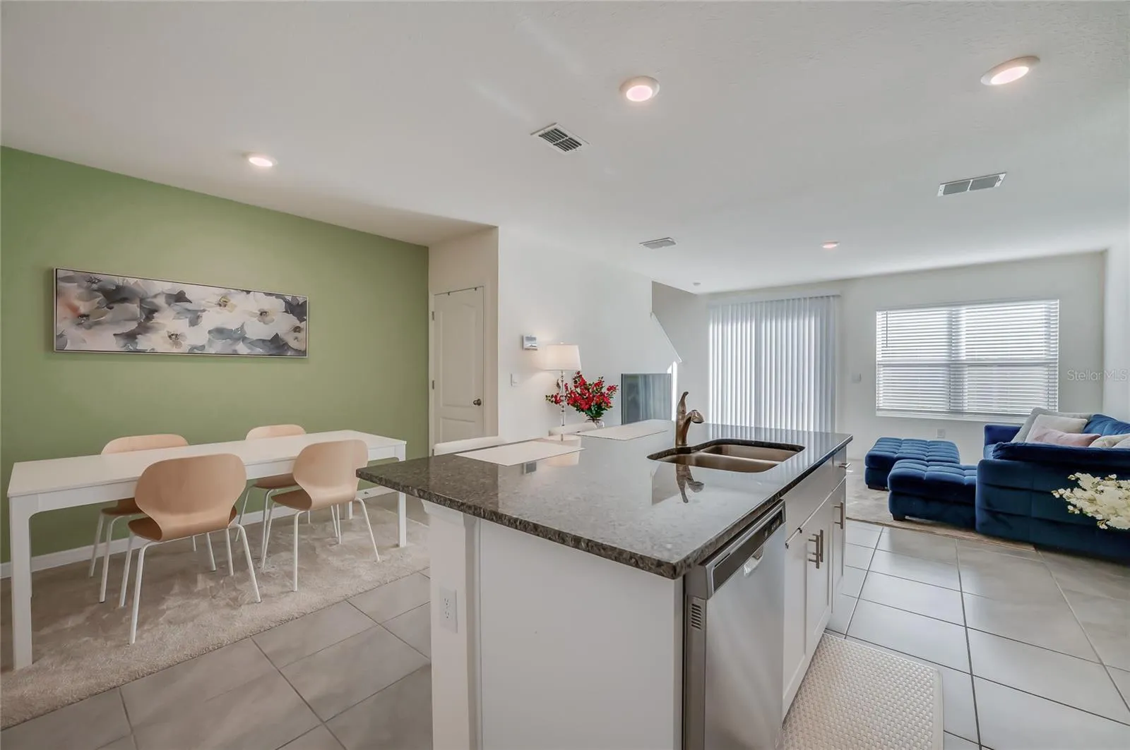 Kitchen, dining, and living spaces connect in an open layout, with natural light extending throughout the main living area.