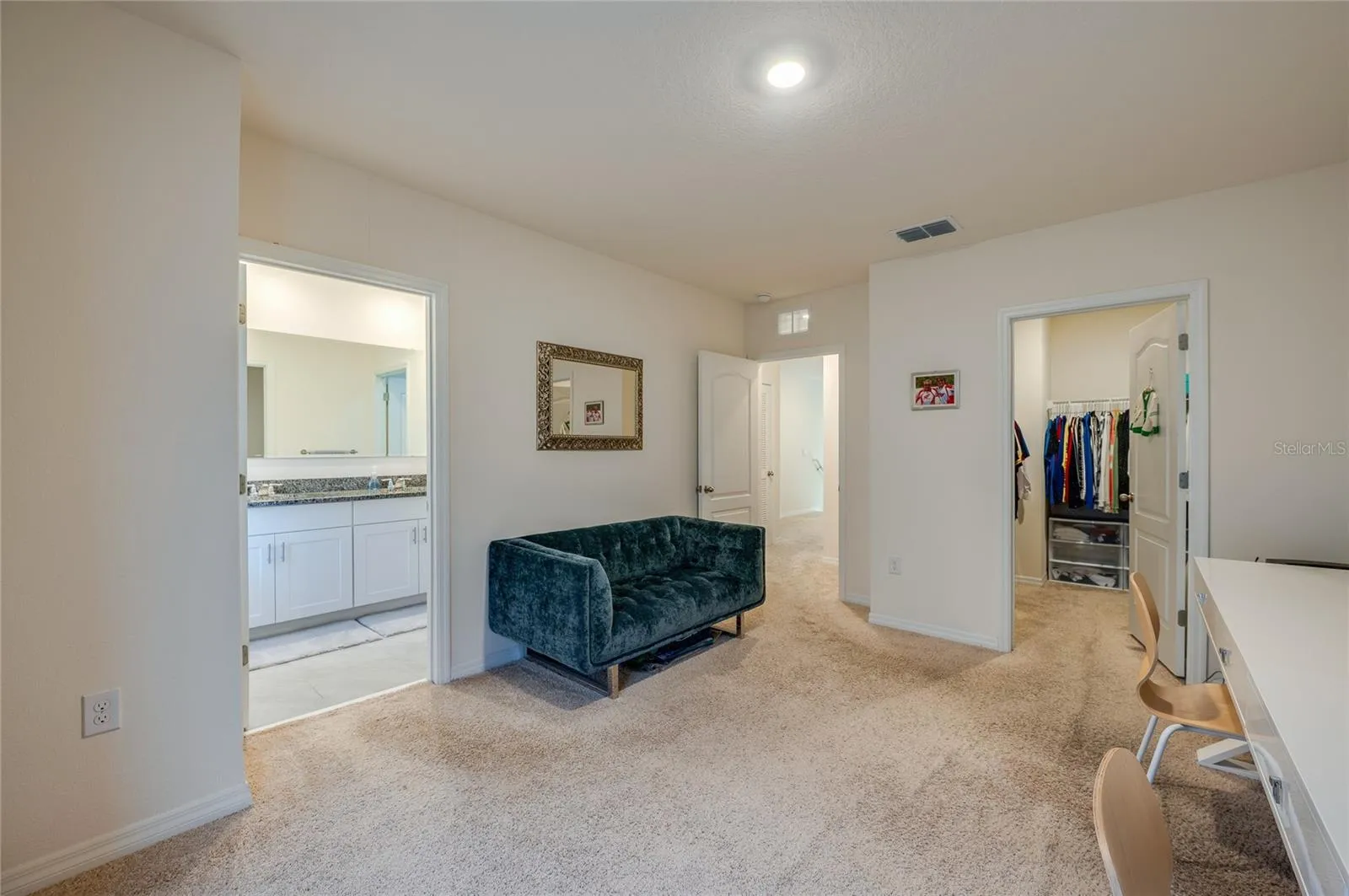 Alternate view of the primary bedroom highlights the generous layout along with direct access to the ensuite bathroom and walk-in closet.
