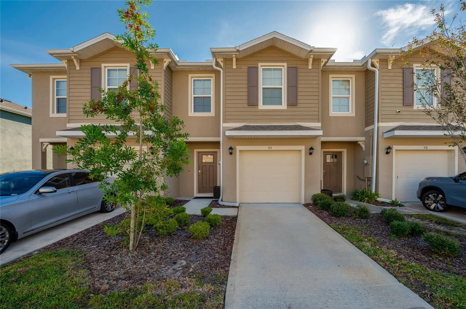 Attractive townhome exterior with an attached garage, covered entry, and neatly maintained landscaping.