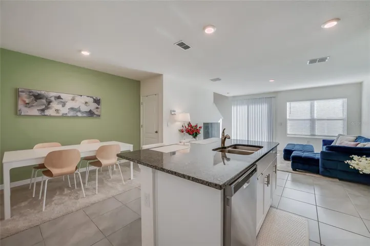 Kitchen, dining, and living spaces connect in an open layout, with natural light extending throughout the main living area.