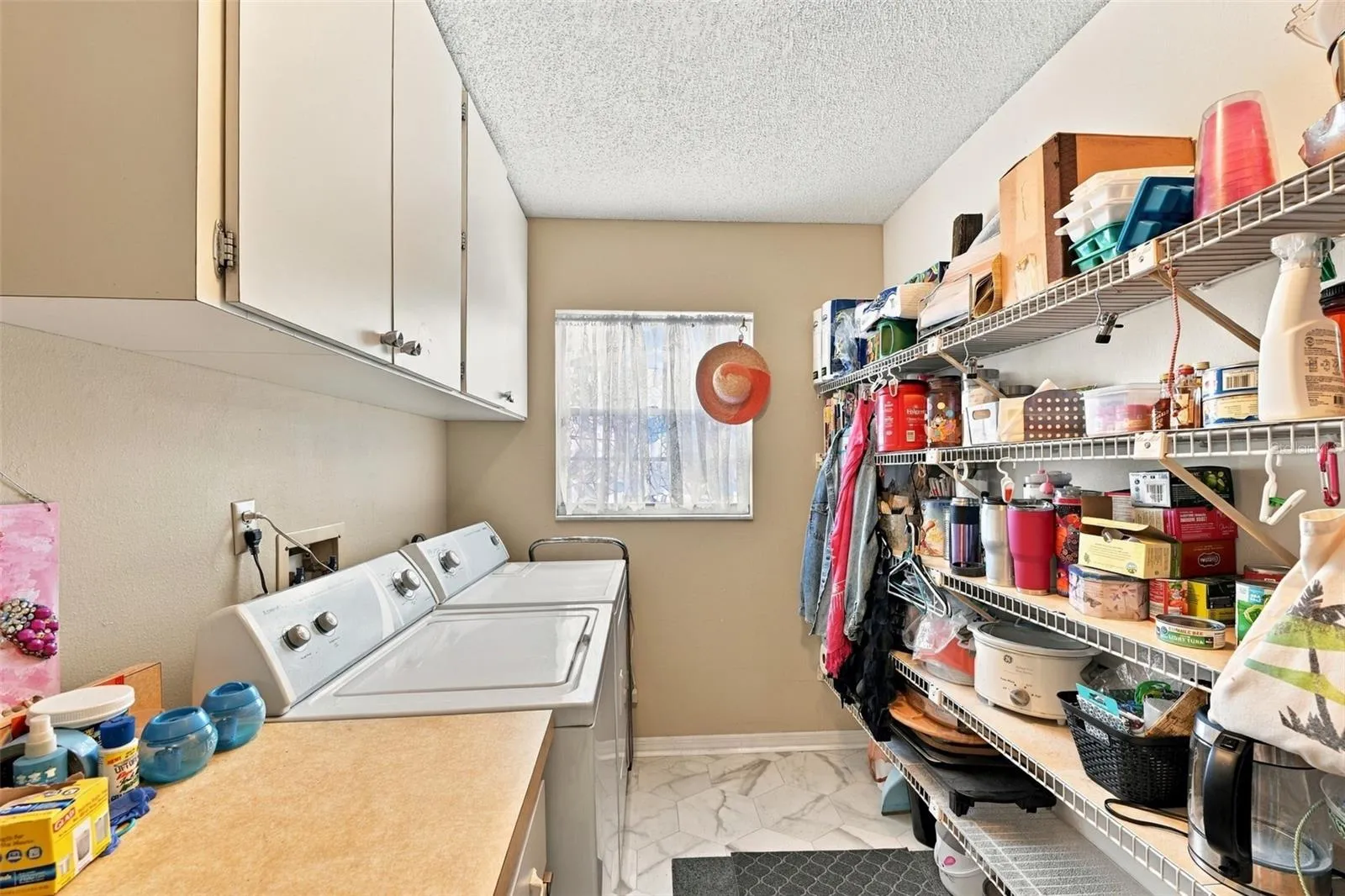 The inside laundry room has lots of storage and cabinetry with new windows for natural sunshine.
