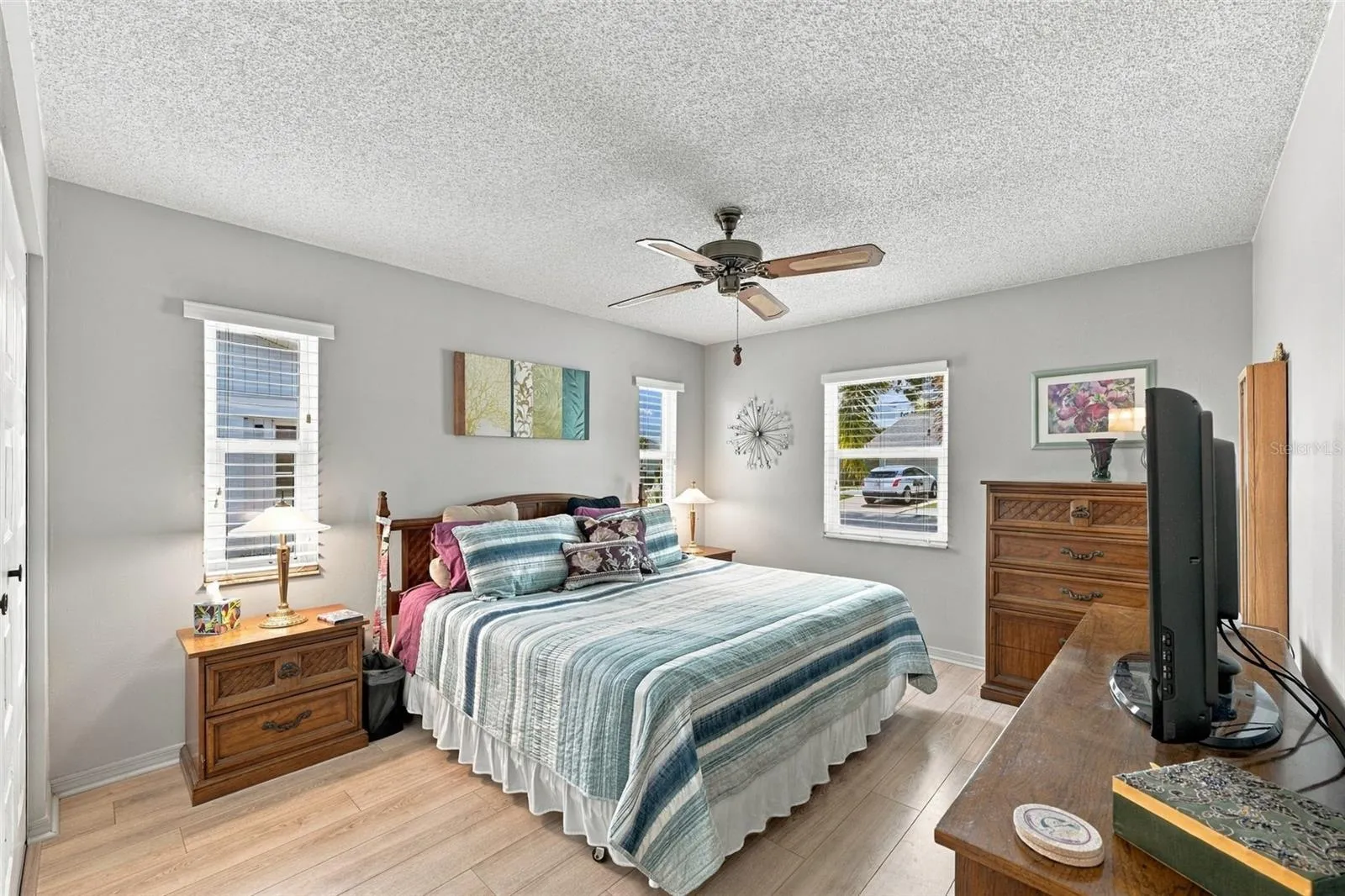 The primary bedroom is spacious with multiple windows and a muted paint tone for relaxation and comfort.