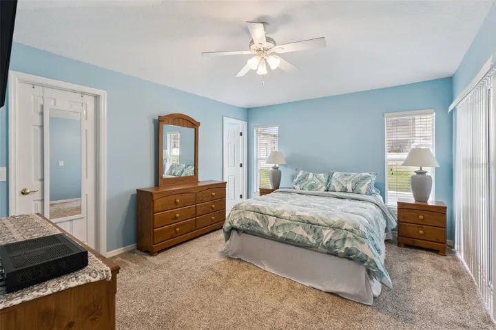 primary bedroom with sliders to pool and patio area