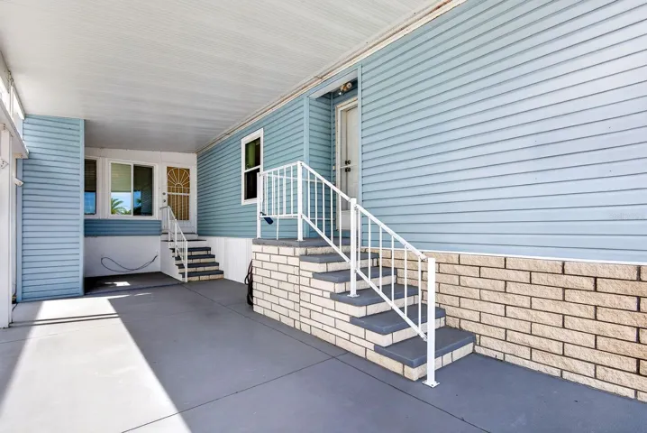 Carport with two entrances one into living area on the right and the other into enclosed lanai sunroom