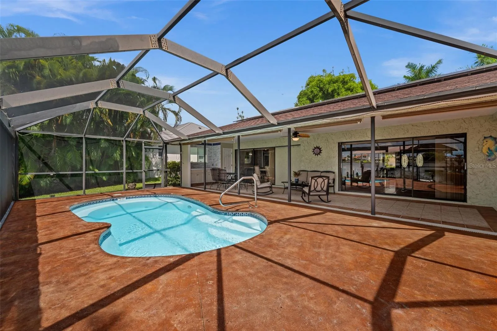 Freeform swimming pool surrounded by a spacious pool deck