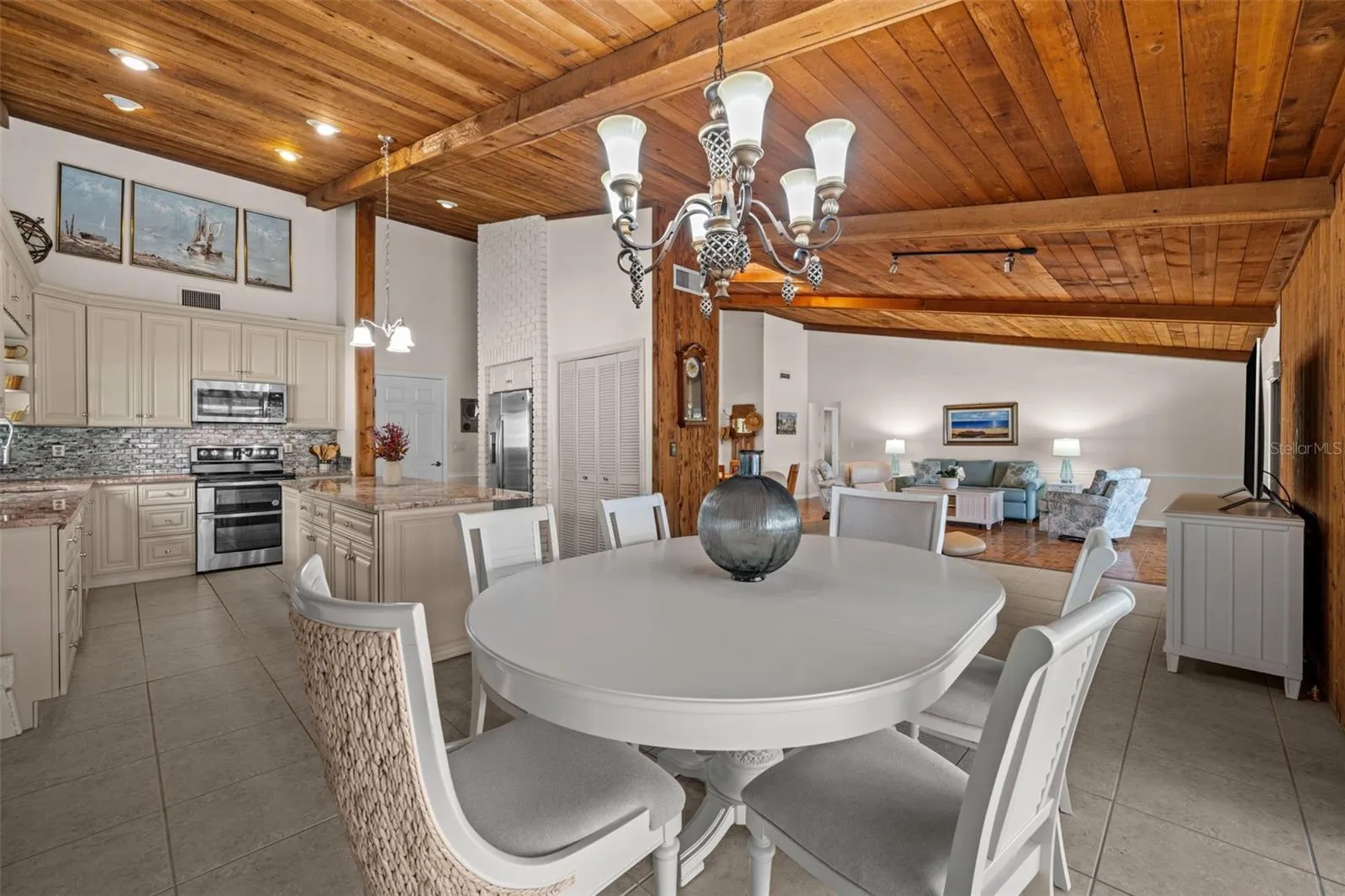 Open kitchen and dining area beneath beautiful wood ceilings