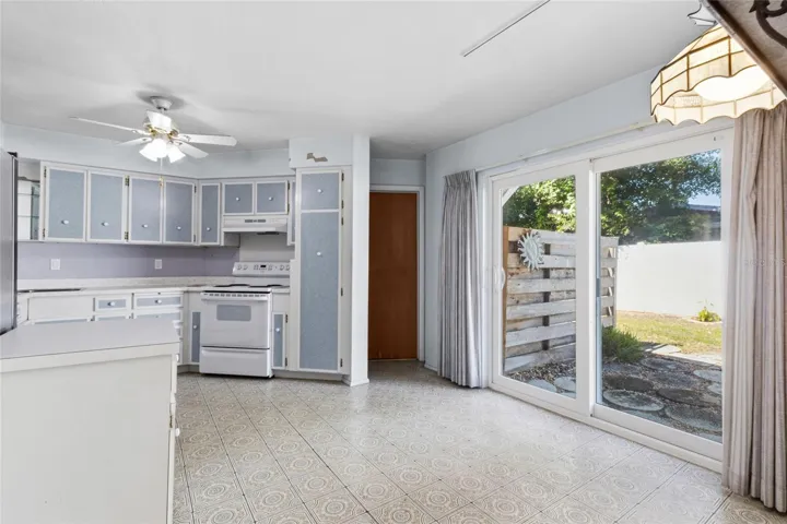 Kitchen from dining area looking at sliders to patio and door to the garage