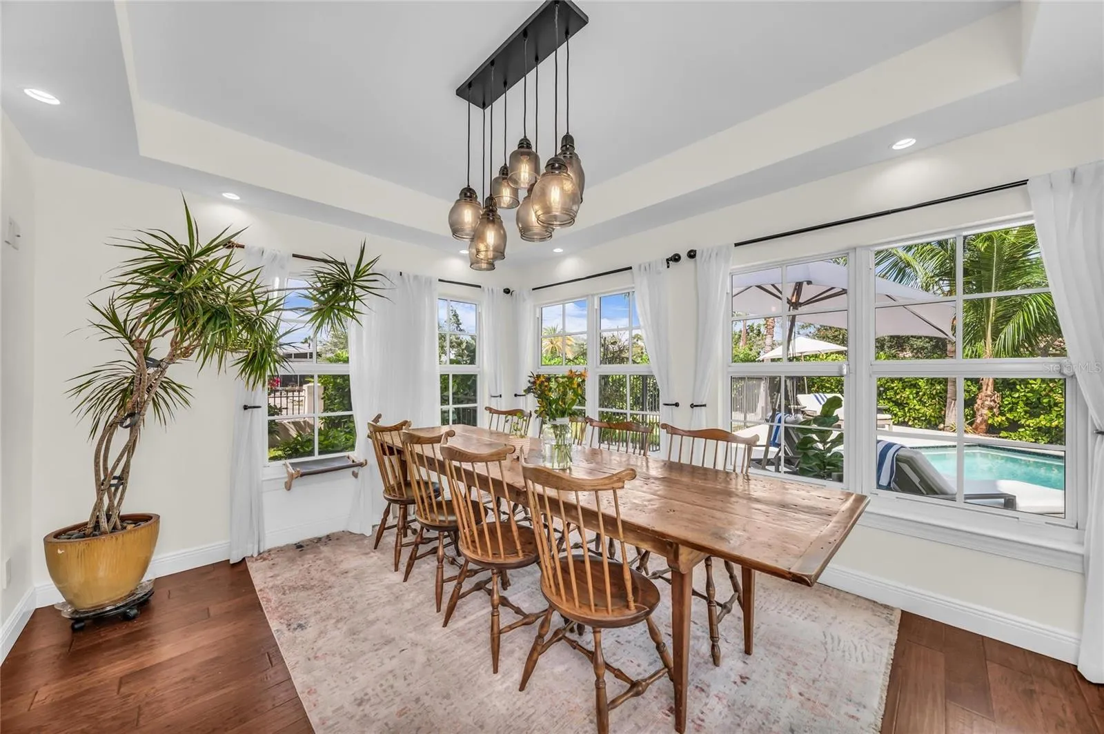 The dining room offers a relaxed atmosphere with ample space for a large dining table and a beautiful view of the pool.