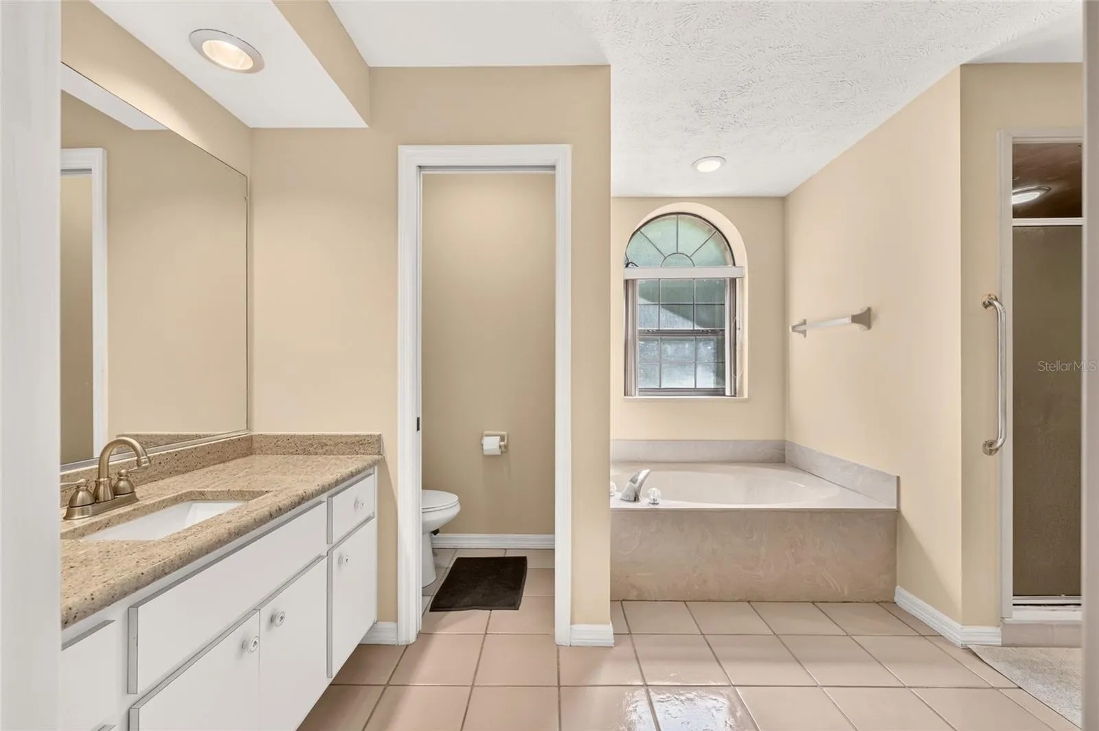 Primary Bathroom with two vanities with granite countertops.