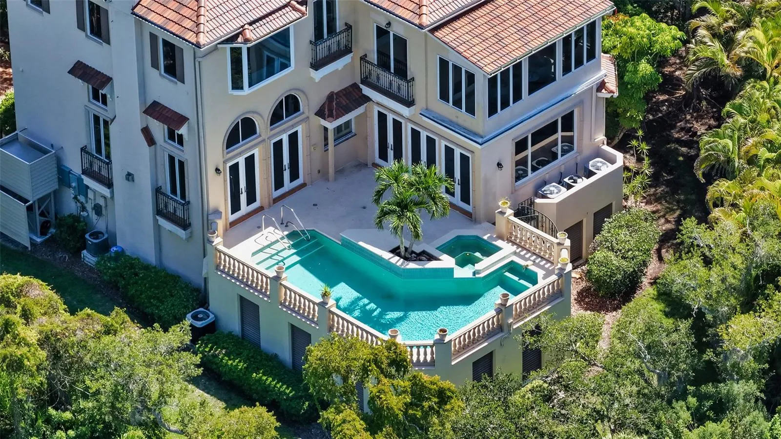 An aerial view highlights the home's elevated pool and spa tucked into the lush surrounding landscape.
