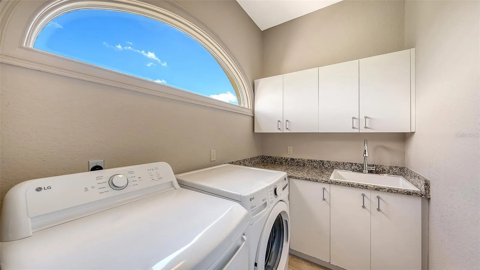 A private laundry area with cabinetry and workspace adds convenience to the primary suite level.