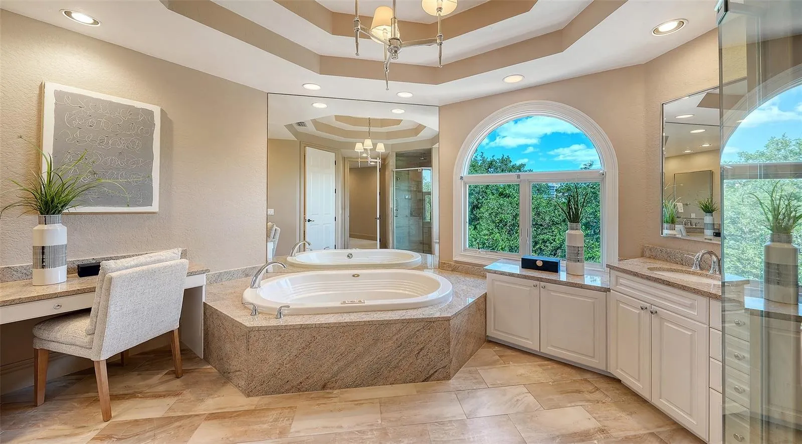 A soaking tub, generous vanity space and graceful architectural detailing create an elegant primary bath.