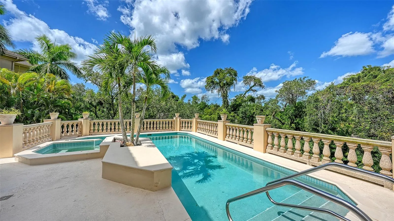 The elevated pool terrace is surrounded by tropical greenery, creating an intimate outdoor retreat.