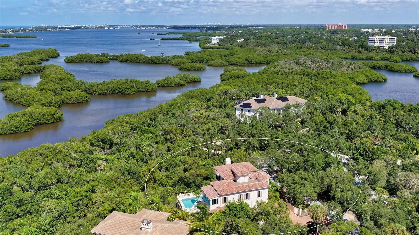 The residence is embraced by mature vegetation and the waterways surrounding Little Sarasota Bay.