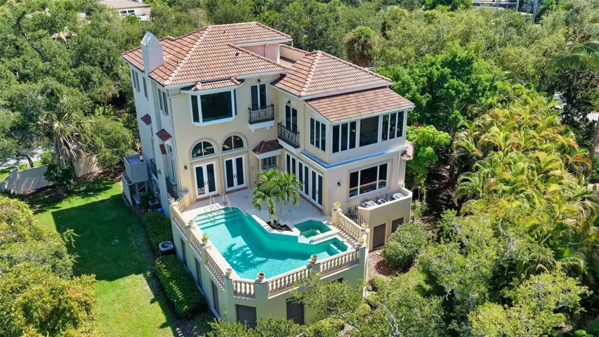 An aerial perspective reveals the home's exceptional privacy, elevated pool terrace and lush natural surroundings.