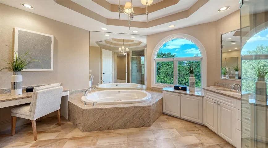 A soaking tub, generous vanity space and graceful architectural detailing create an elegant primary bath.