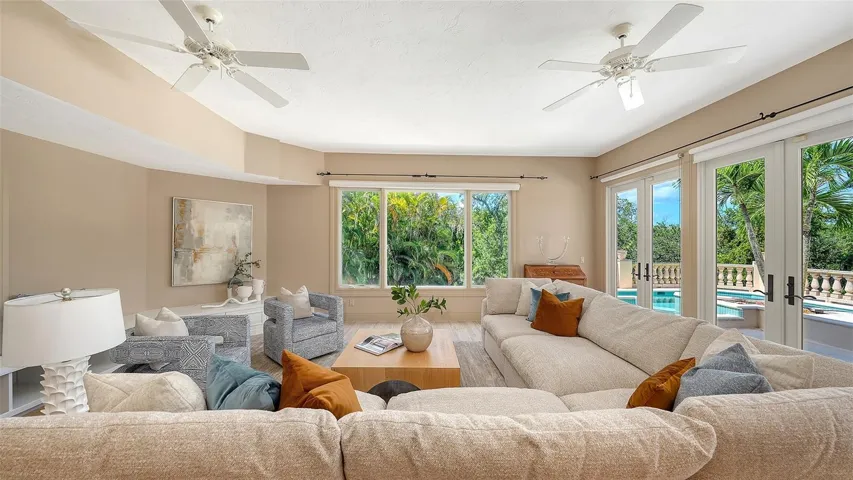 Expansive windows and French doors surround this comfortable gathering space with views of the lush tropical setting.