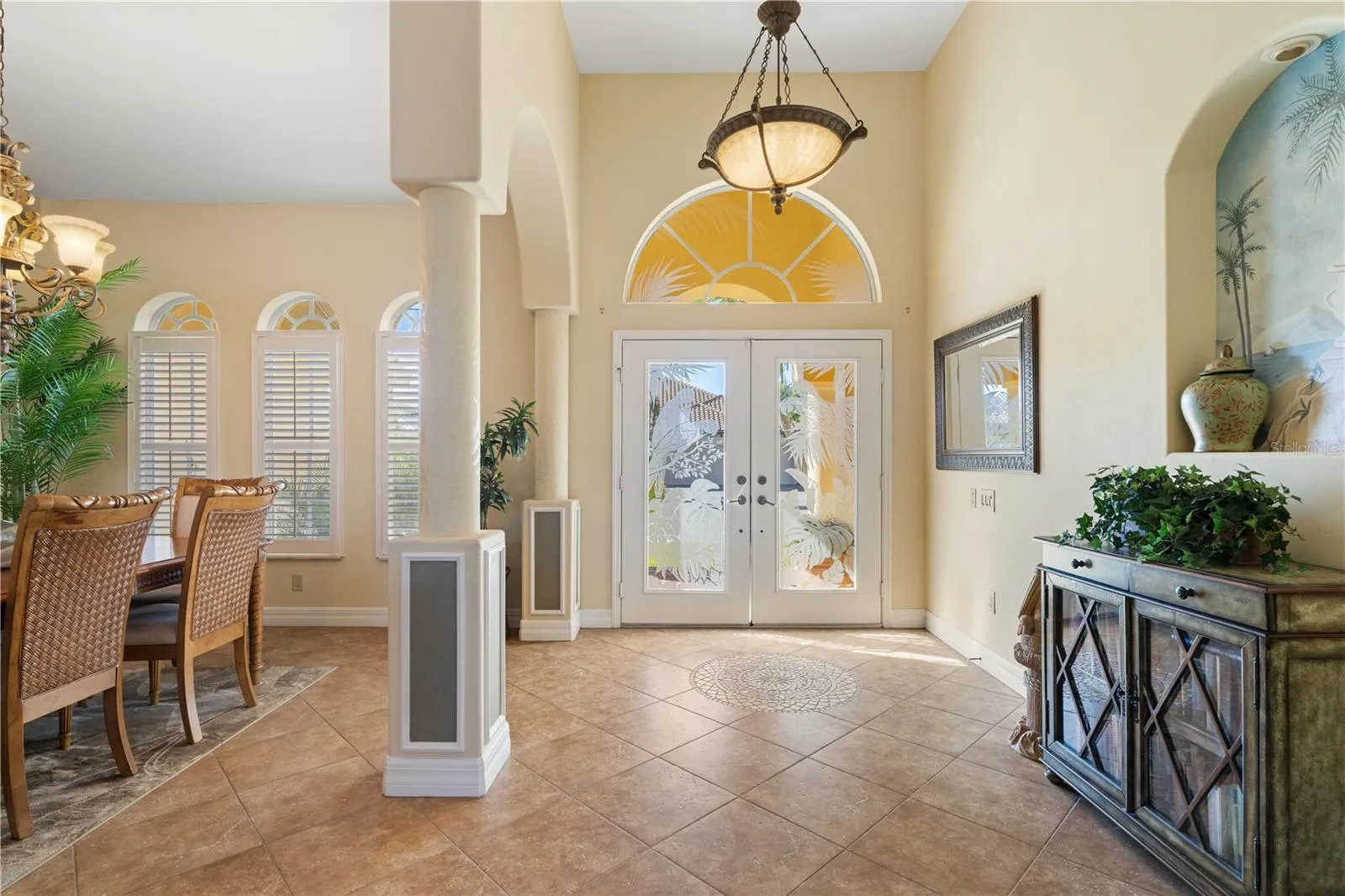 Foyer with columns. Arched transom window above front door.