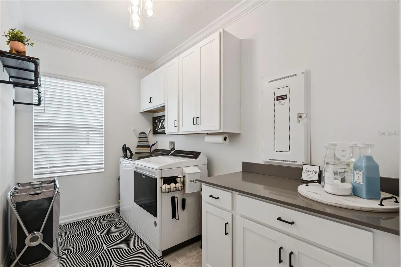 2nd floor oversized laundry room adjacent to owner's suite with stone counter top and plenty of cabinet space