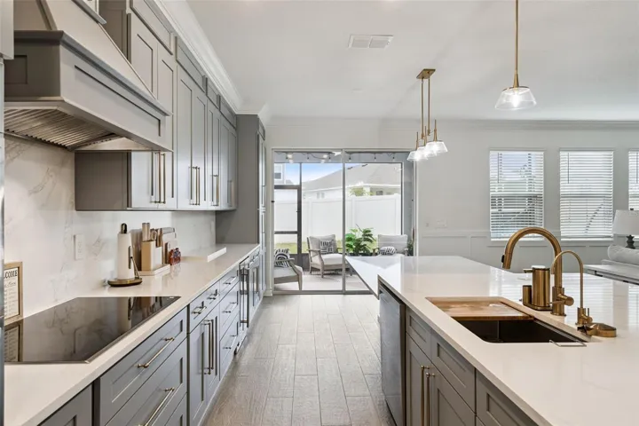 Marble backsplash, upgraded 36" smart induction cooktop with wifi and virtual flame technology, custom designer vent hood kitchen floor to ceiling custom cabinetry and fnishes , beautiful quartz counter tops