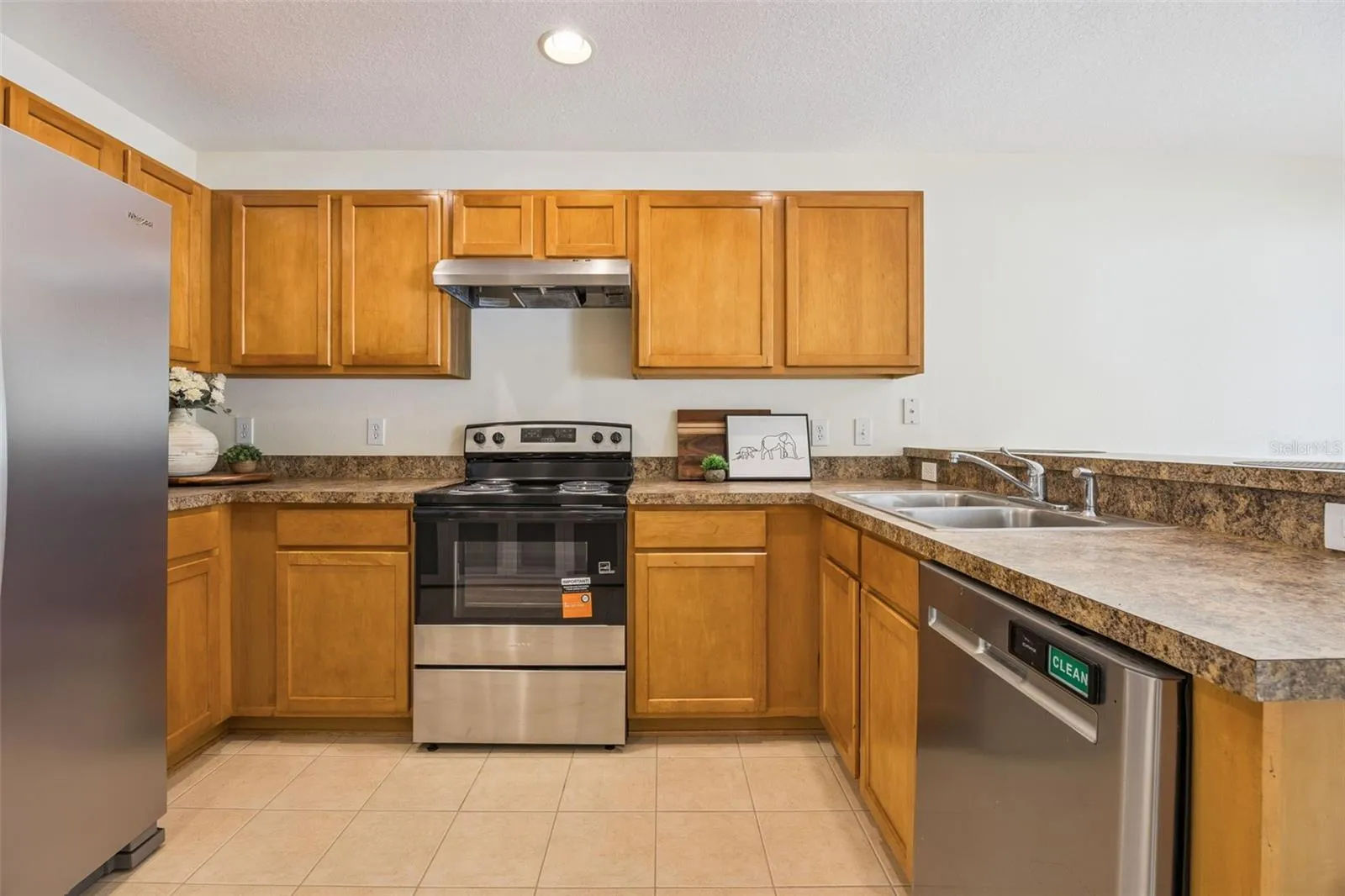 Kitchen with new refrigerator, range and range hood