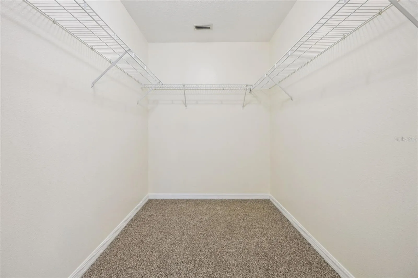 Primary walk-in closet (6'4" x 8'11") with new wire shelving