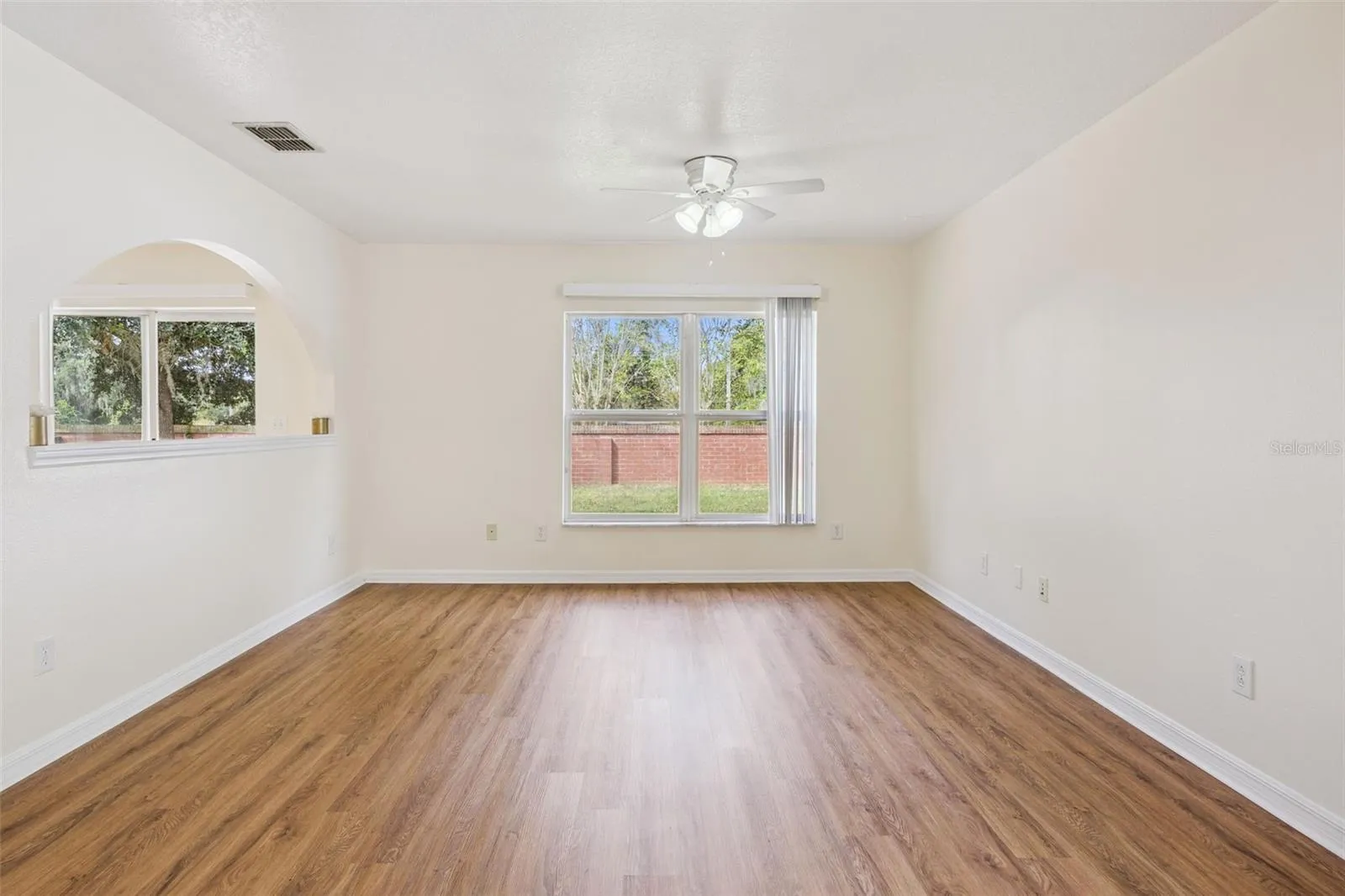 Family room (12'10" x 14'3") with new LVP flooring and arched pass-through to the breakfast nook