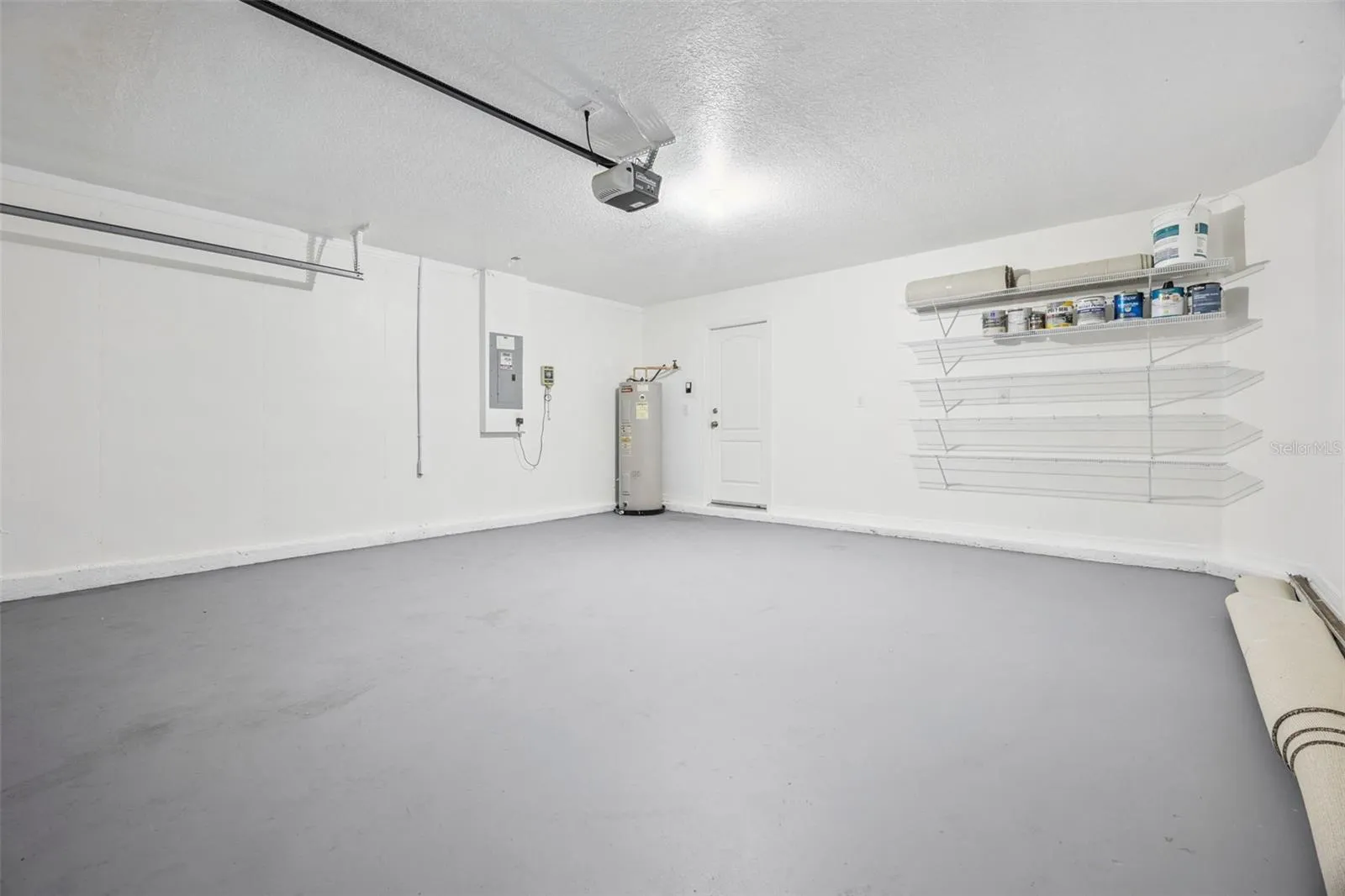 Two-car garage (18'8" x 19'6") with freshly painted floor and new wire storage