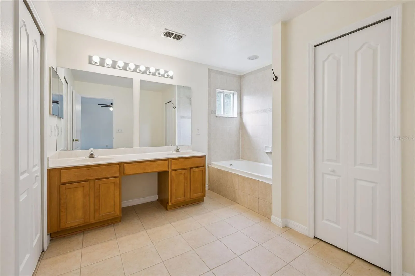 Primary bath (9'7" x 10'7") with dual sinks, vanity and garden tub
