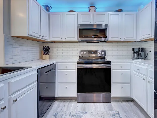 Kitchen has newer stainless-steel appliances, many storage cabinets and subway backsplash.