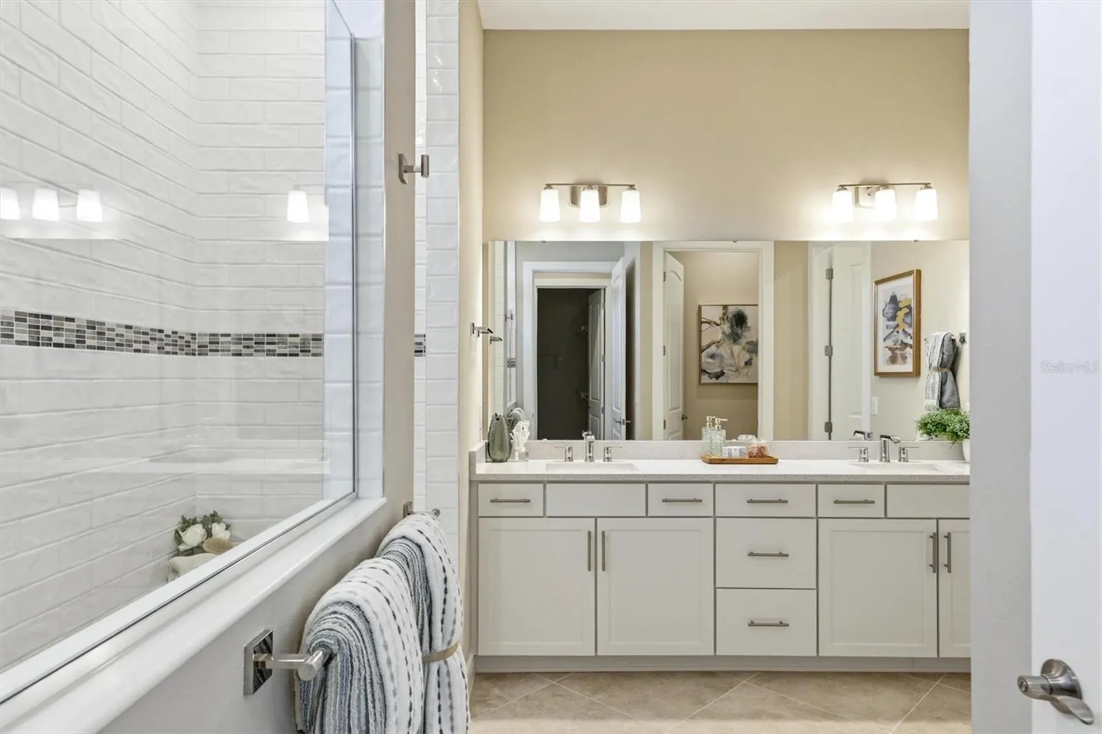 Primary bath features a floor to ceiling tiled WAL IN super shower with bench