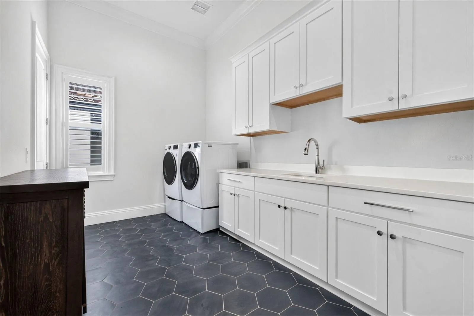 Thoughtfully Designed Laundry Room with Ample Cabinetry and Utility Sink
