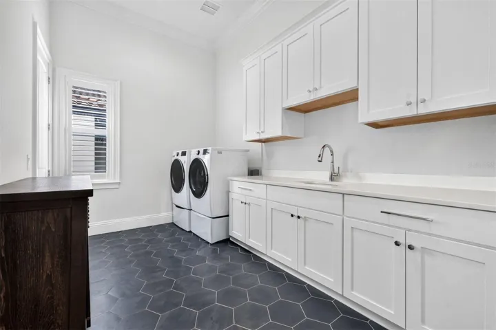 Thoughtfully Designed Laundry Room with Ample Cabinetry and Utility Sink