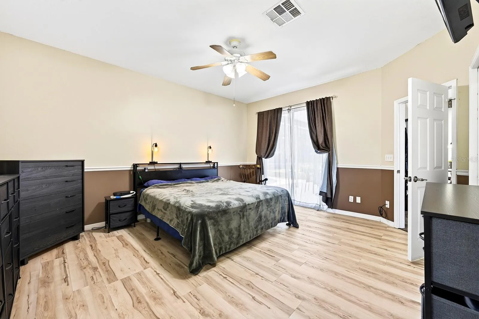 The Primary Suite features LAMINATE FLOORING, a large walk-in closet, EN SUITE BATH, and sliding doors leading to the patio and pool.
