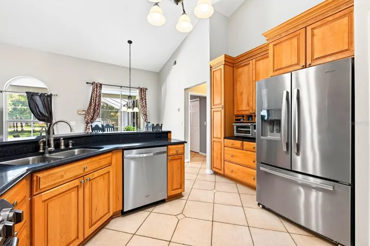 The Kitchen is both spacious and functional, featuring an abundance of SOLID-WOOD CABINETRY, generous counter space, modern tile backsplash, STAINLESS-STEEL APPLIANCES, pantry closet and breakfast bar.