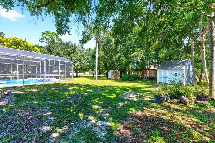 Beyond the lanai, the FENCED BACKYARD offers plenty of room to enjoy the outdoors, with mature trees providing shade and privacy.