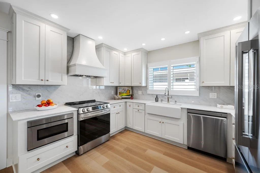 Plenty of solid wood cabinetry, marble countertops and backsplash, recessed lighting