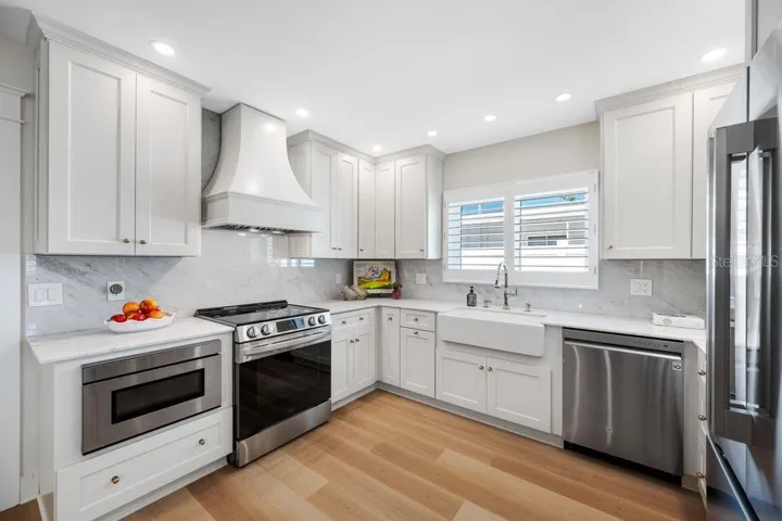 Plenty of solid wood cabinetry, marble countertops and backsplash, recessed lighting