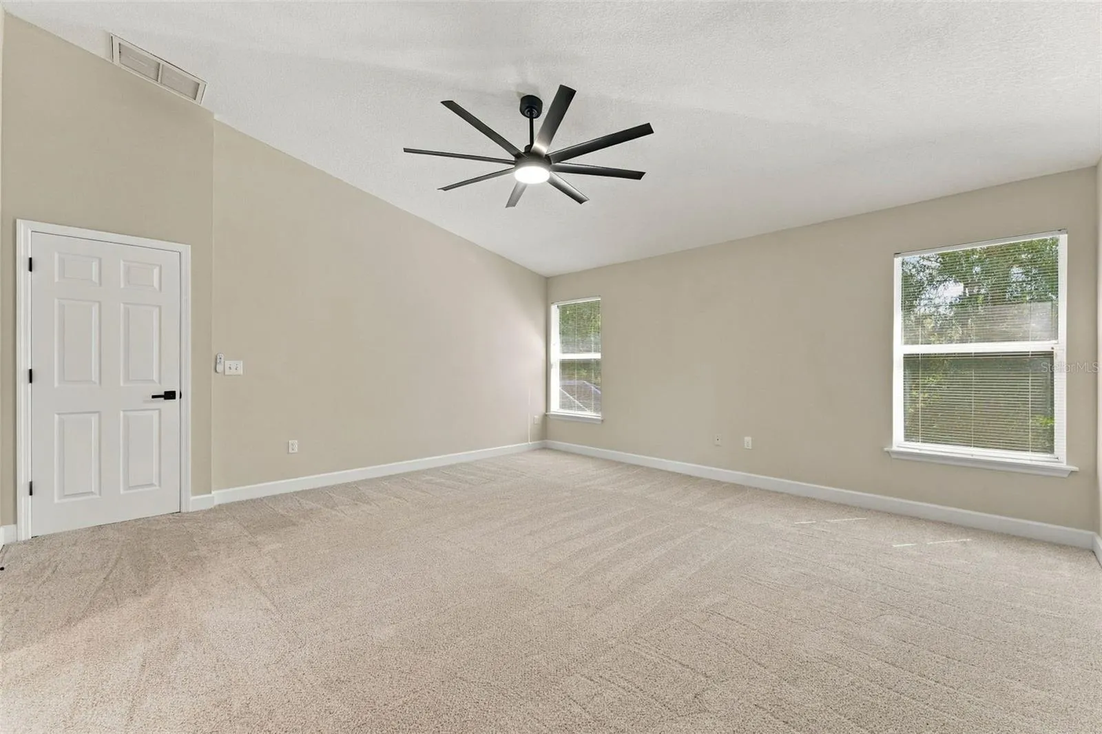 Primary bedroom with brand new carpet and ceiling fan