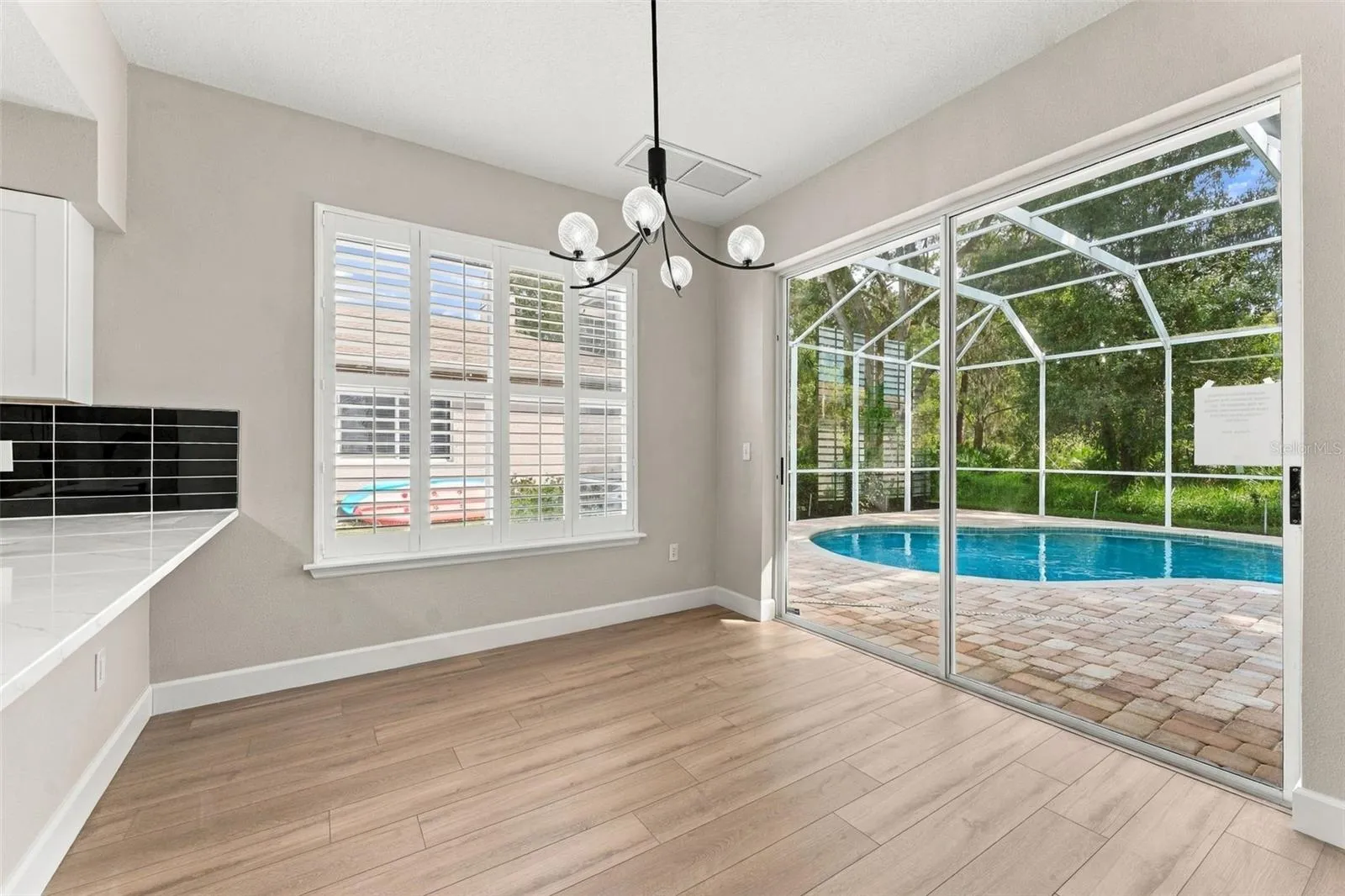 Breakfast nook located off the kitchen with a great view of the pool and woods behind your home