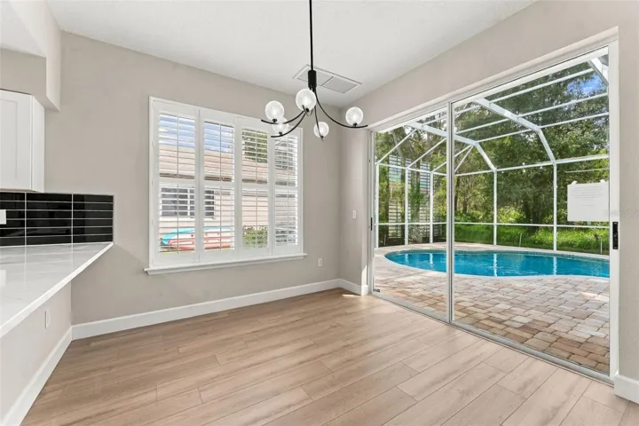 Breakfast nook located off the kitchen with a great view of the pool and woods behind your home
