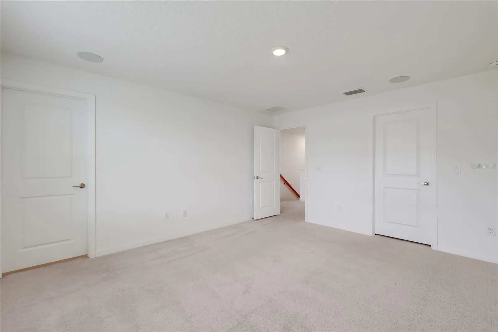 The master bedroom has its own master bathroom (shown with the door shut) and speakers in the ceiling as part of the full-house stereo system!