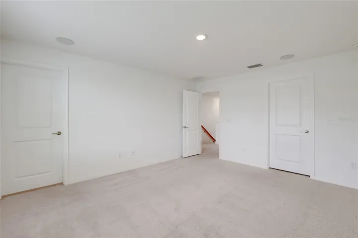 The master bedroom has its own master bathroom (shown with the door shut) and speakers in the ceiling as part of the full-house stereo system!