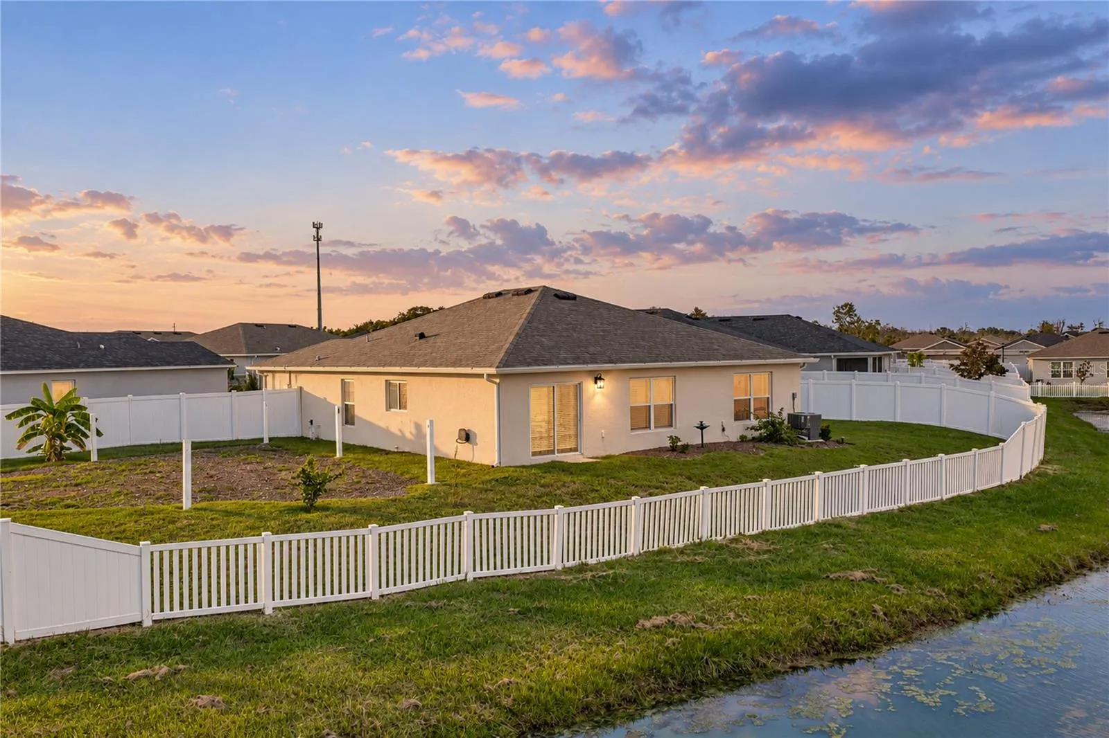 Back fenced yard with pond view