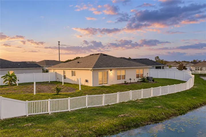 Back fenced yard with pond view