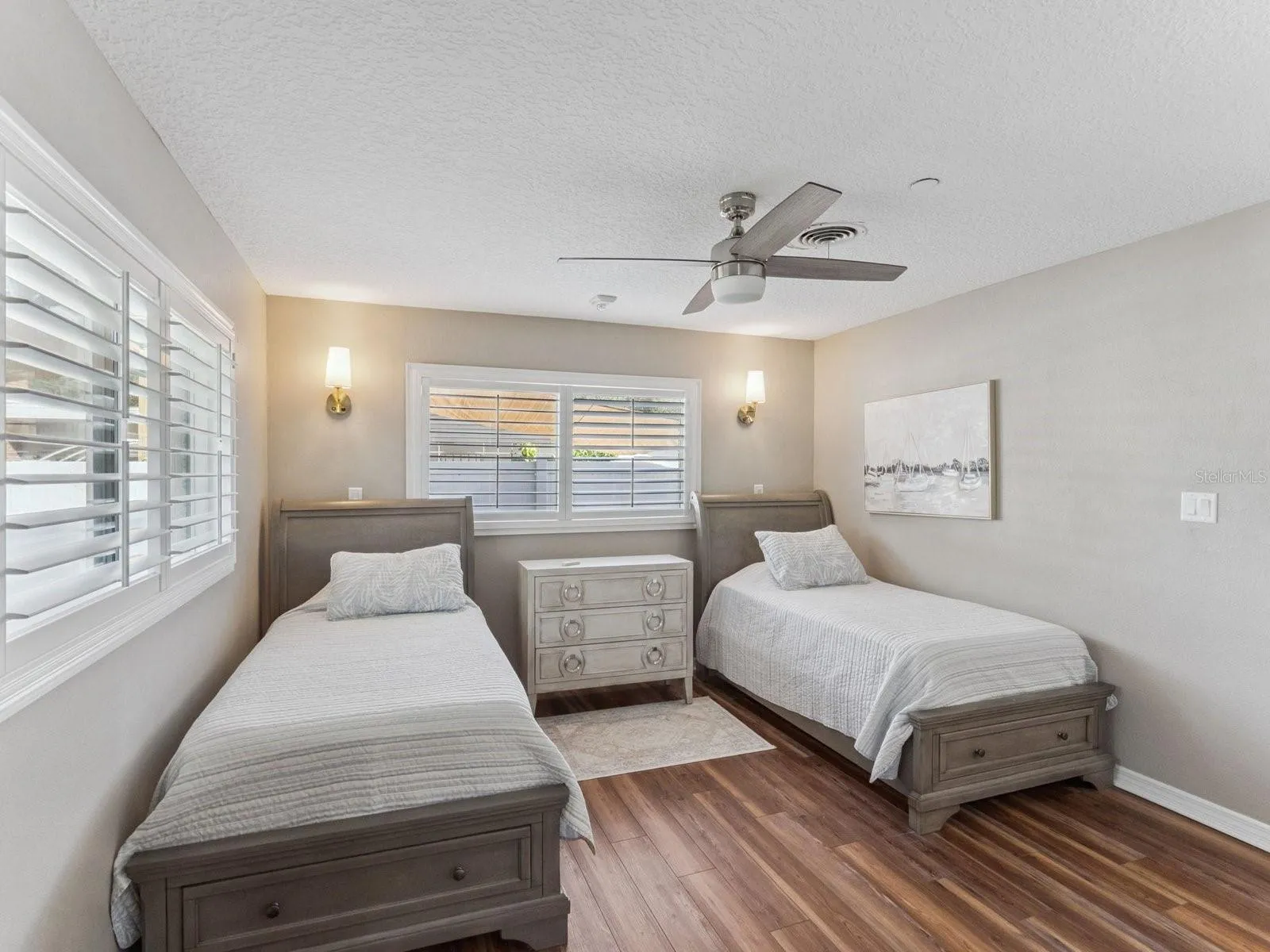 Bedroom with ceiling fan and wall sconces